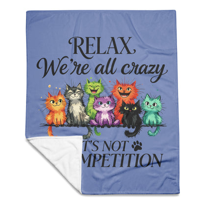 50 by 60 inch blue throw blanket with a white sherpa lining, featuring a graphic of seven colorful cartoon cats and the text 'RELAX We're all crazy IT'S NOT COMPETITION'.Product mockup