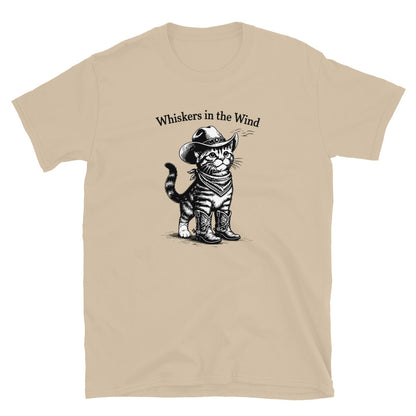 Beige t-shirt with a graphic of a cat wearing a cowboy hat and boots, and the text 'Whiskers in the Wind'.