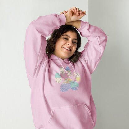 Person wearing a pink hoodie with colorful paw print design on a plain background