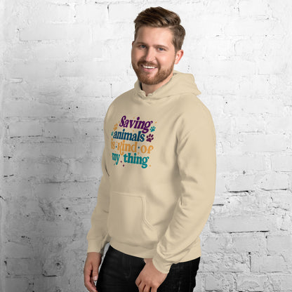 Man wearing a tan Hooded Sweatshirt that reads Saving Animals is kind of my Thing with several paw print and sparkle images in a purple, yellow and blue font.