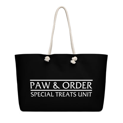 Front view of a Black tote bag with tan rope handles. Design is black with white lettering that reads: Paw & Order- Special Treats Unit
