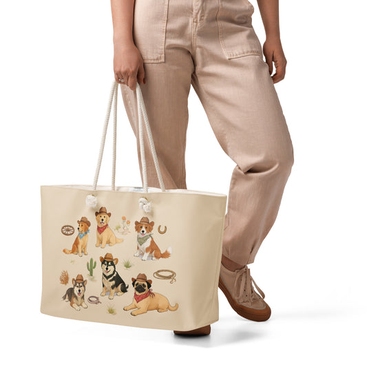 Beige tote bag with dog illustrations held by a person wearing beige pants and brown shoes on a white background