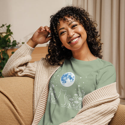 Woman wearing a green t-shirt with a cat and moon design, sitting on a couch.